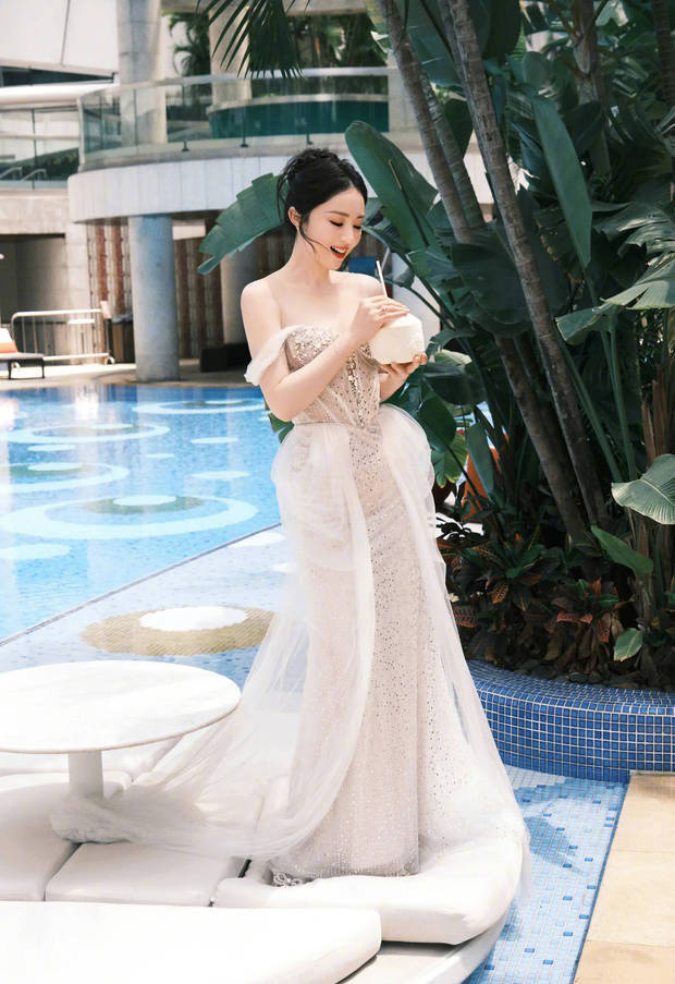 董璇泳池畔饮椰水笑容灿烂，一袭礼裙勾勒曼妙身姿尽显惬意 -1