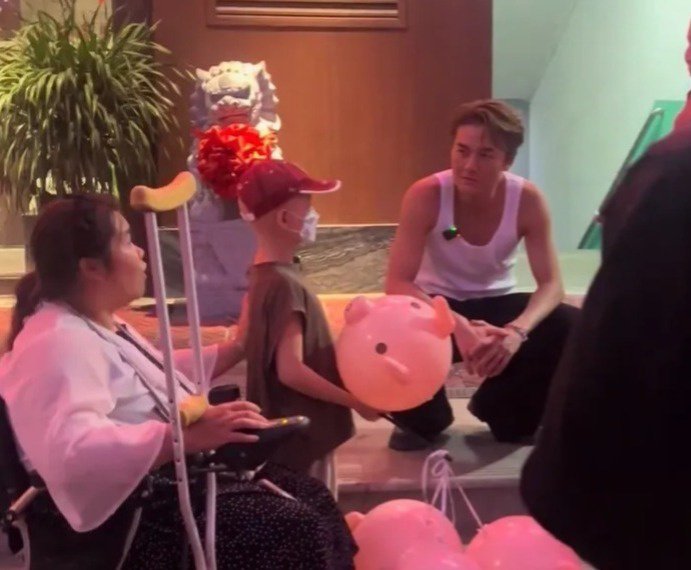 吴克群现身街头帮患病母子卖花，当事人回应：他就像邻家大哥 -1